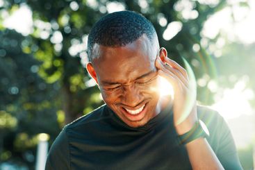 Fitness, headache and man outdoor, tired and African...