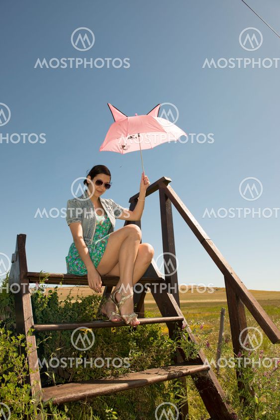 Beautiful adult smelling flowers on sunny field enjoying herself