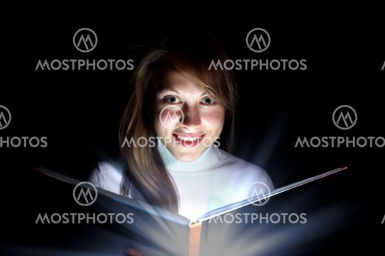 Young woman reading a magic book