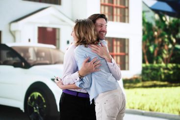 Smiling Couple Buys Red Car