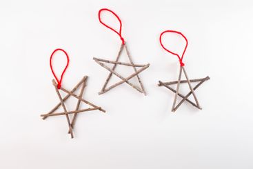 Three star shaped figures made from twigs, tied at...