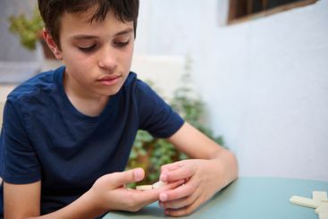 Young boy concentrating while playing a board game...