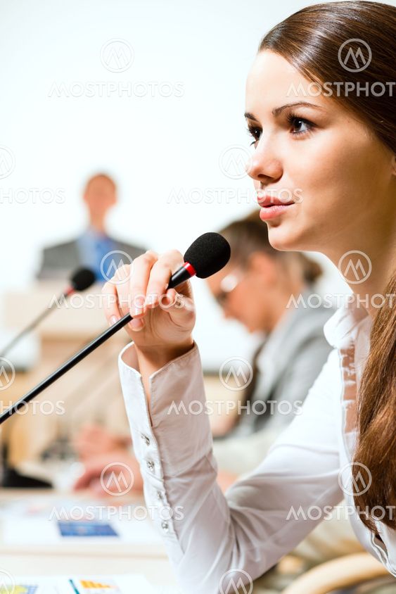 Business woman speaks into a microphone