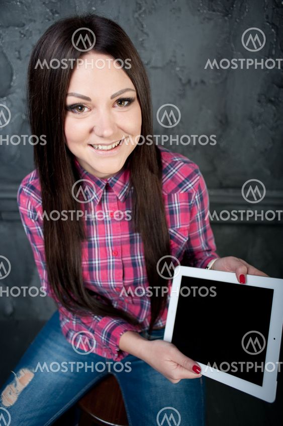 The young girl dreams and holds the touchpad