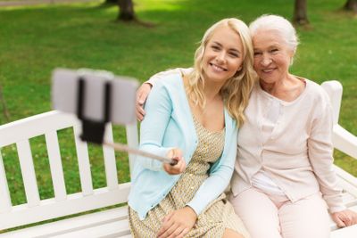 daughter and senior mother taking selfie at park