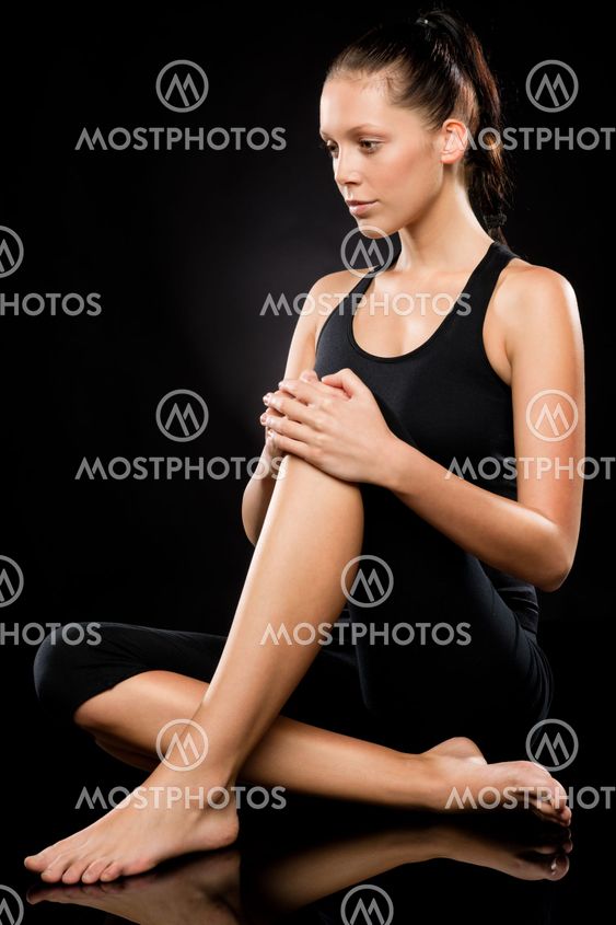 Sporty brunette woman relaxing while doing yoga