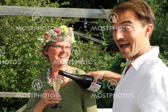 Younger man serves older woman champagne