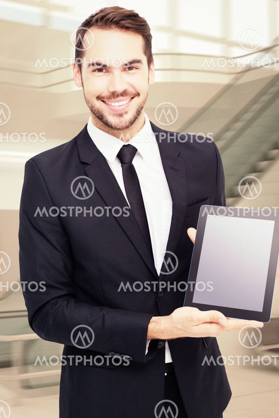 Composite image of smiling businessman showing his tablet pc