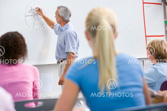 A teacher talks to school children in a high school class