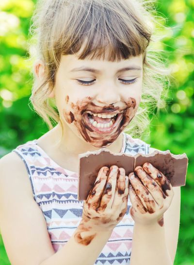 A sweet-toothed child eats chocolate. Selective focus.
