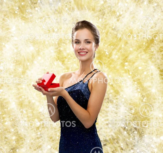 smiling woman in evening dress with red gift box