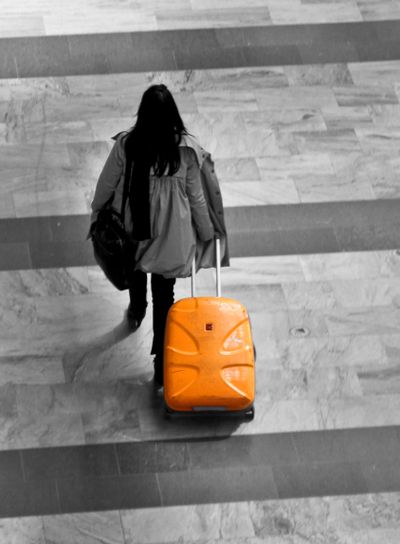 Kvinna med gul resväska