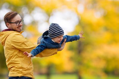father with son playing and having fun in autumn