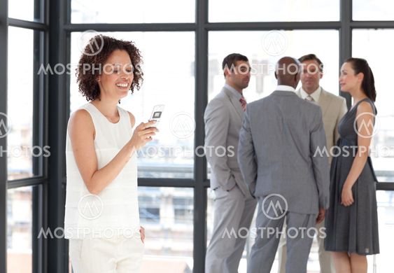 Businesswoman holding a phone at workplace with his colleagues
