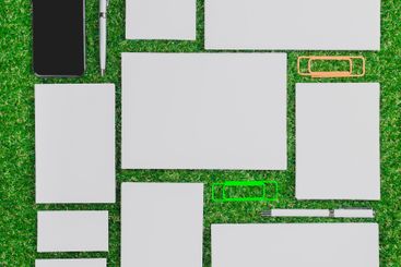 Assorted stationery items arranged on green grass in a...