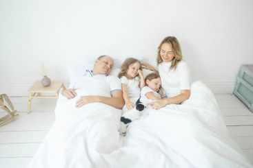 Happy morning. Family relaxing on the bed together at home