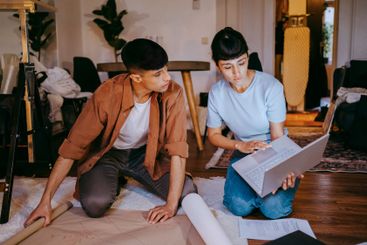 Young male and female freelancers using laptop while...