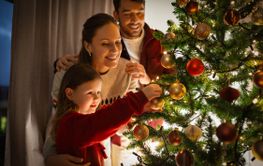 happy family decorating christmas tree at home