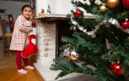 Flicka letar paket i julstrumpan