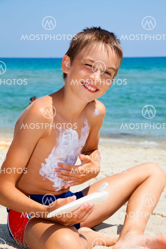 Boy eating melon on a beach