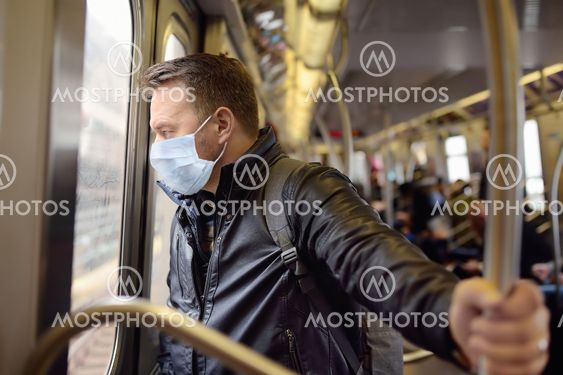 Mature man wearing disposable medical face mask in car...