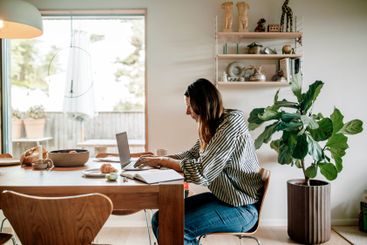 Side view of focused businesswoman working on laptop...