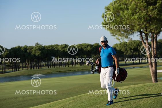 golf player walking and carrying bag