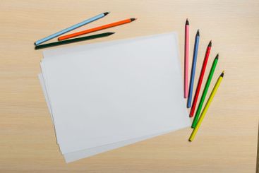 Colorful pencils and blank sheets waiting for artistic...