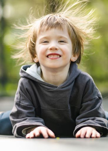 Little boy jumping on a trampoline in a backyard on warm...