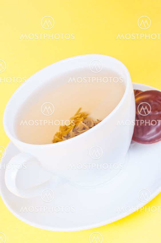 Cup of green tea on the saucer and cookies