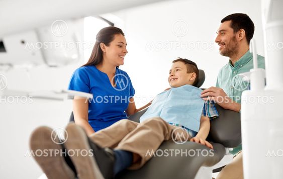 female dentist with kid patient at dental clinic
