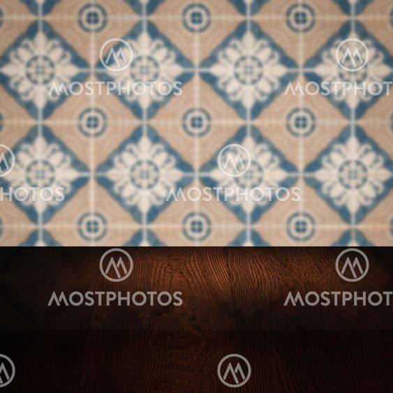 Wood table top and blur vintage ceramic tile pattern wall