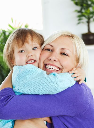 Attentive mother hugging her little daughter