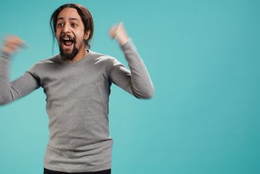 Man jumping from joy in excitement while cheering for...