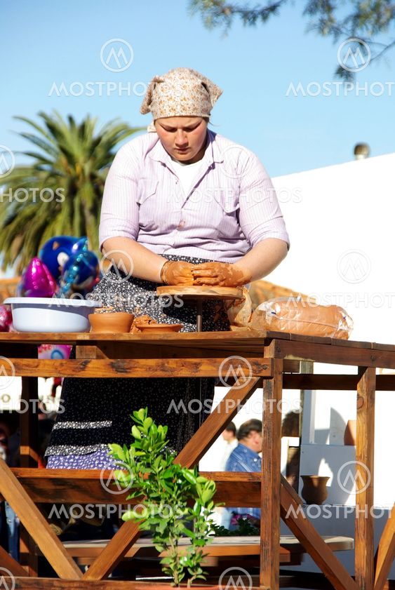 Woman works in the pottery wheel