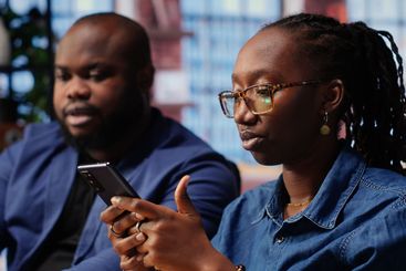 Black couple sitting together at home office and...