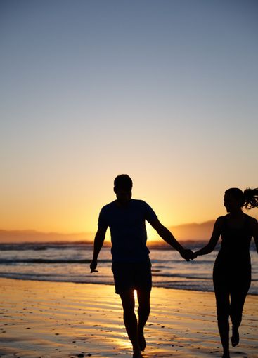 Couple, silhouette and holding hands by ocean, sunset...