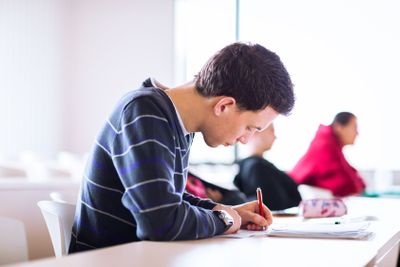 young, handsome male college student sitting in a...