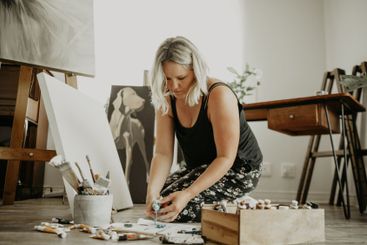 Paint, canvas and girl on floor at studio for artwork...