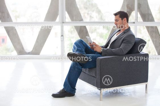 Good looking man in his 20s working on a mini think pad