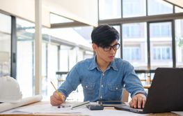 Architect and engineer working on blueprints using a...