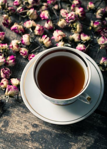 Vintage teapot and cup with blooming tea flowers on...
