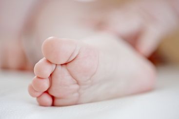 Sleeping, baby and closeup of foot, nursery and nap for...