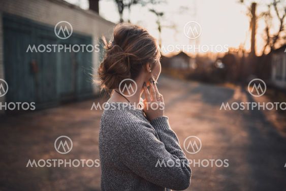 woman with hair tied in a bun in gray knitted sweater On...