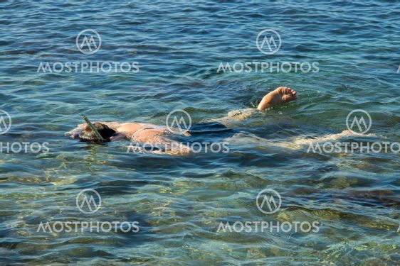 Adult woman diving into clear water of sea