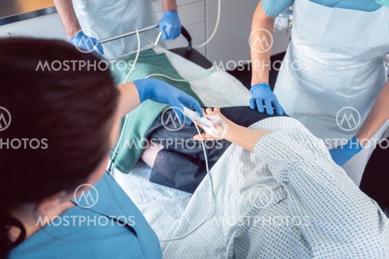 Team of doctors and nurses performing colonoscopy