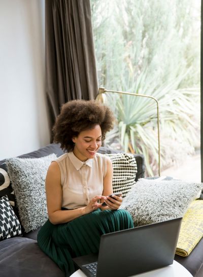 Attractive young woman working on laptop and using...