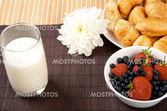 Breakfast with berries, milk and croissant