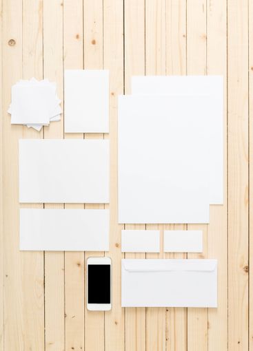 Blank stationery and smartphone arranged on wooden table...
