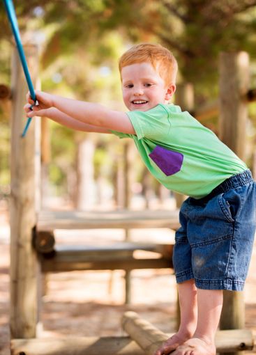 Smile, child and rope at playground outdoor for fun...